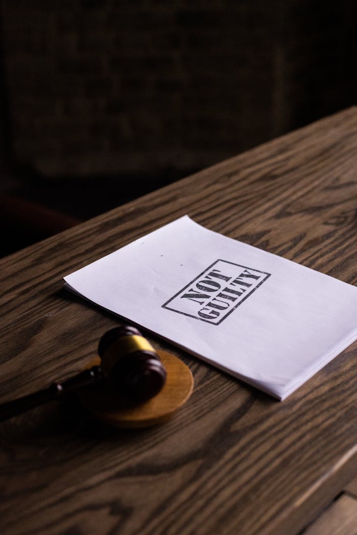 creative A legal gavel next to a 'Not Guilty' document on a wooden table, symbolizing justice.