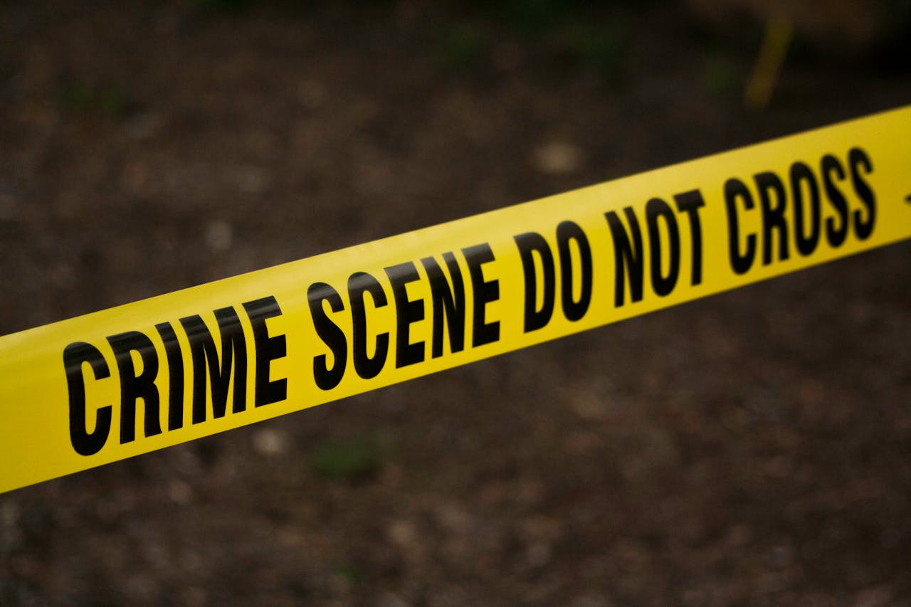 why-choose-us Close-up of crime scene tape with 'Do Not Cross' text, outdoors setting.